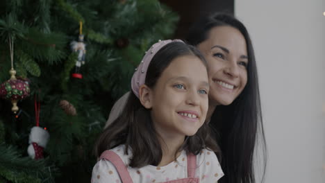 mother and daughter by christmas tree