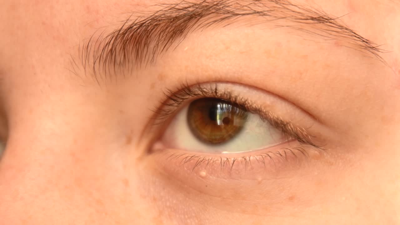 주근깨가 있는 젊은 빨간 머리 여성의 연한 갈색 눈을 감고 눈을 돌리고 카메라를 쳐다보며 화장을 하지 않은 채