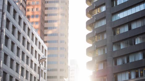 Cityscape-with-modern-buildings-and-sun-shining-over-clear-sky