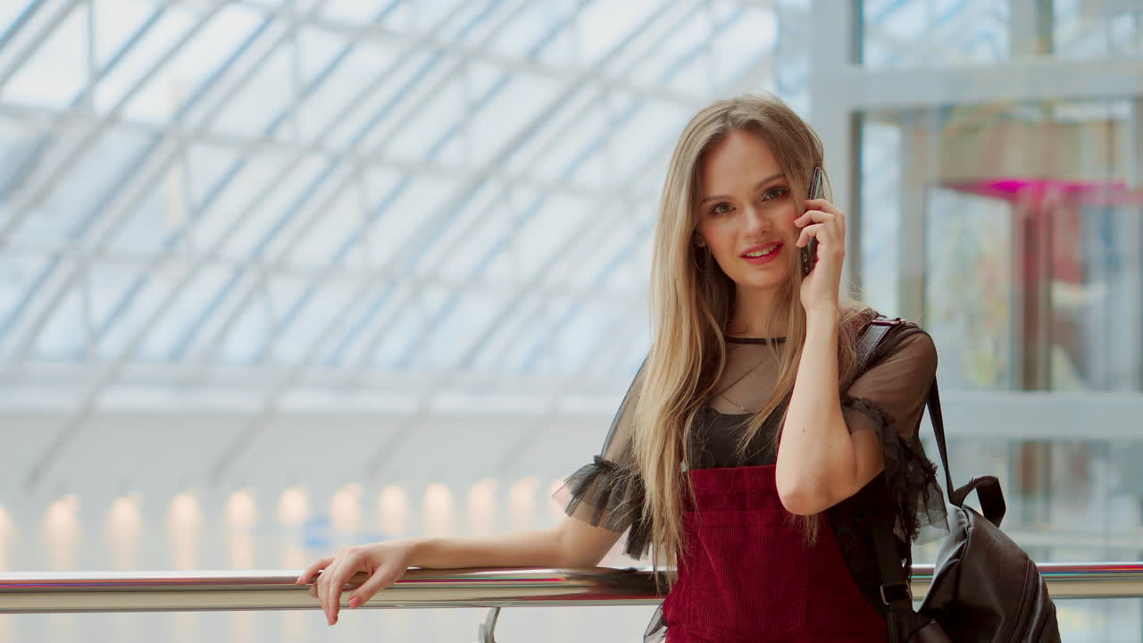 행복 한 여성 쇼핑객 이 전화 로 이야기 하고 미소 짓고 있다