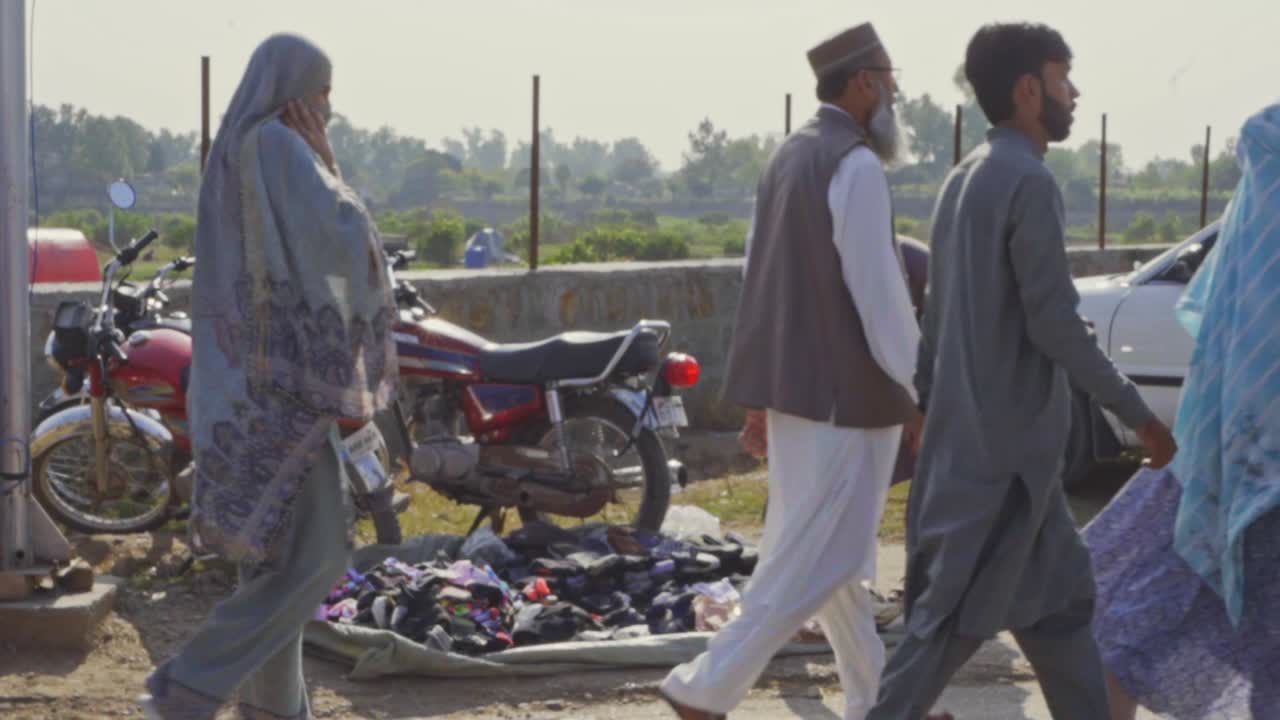 In a busy location, a vendor is selling vibrant winter socks for both children and adults at a quaint roadside stand.