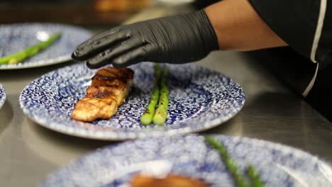 chef plating grilled fish with asparagus