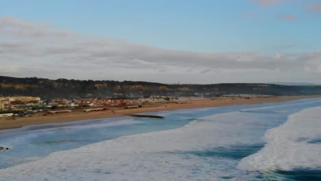 Drohnenschuss-Parallaxe-Am-Strand-Und-Den-Schaumigen-Weißen-Wellen