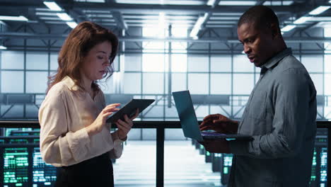 Portrait of happy system administrators in data center using devices