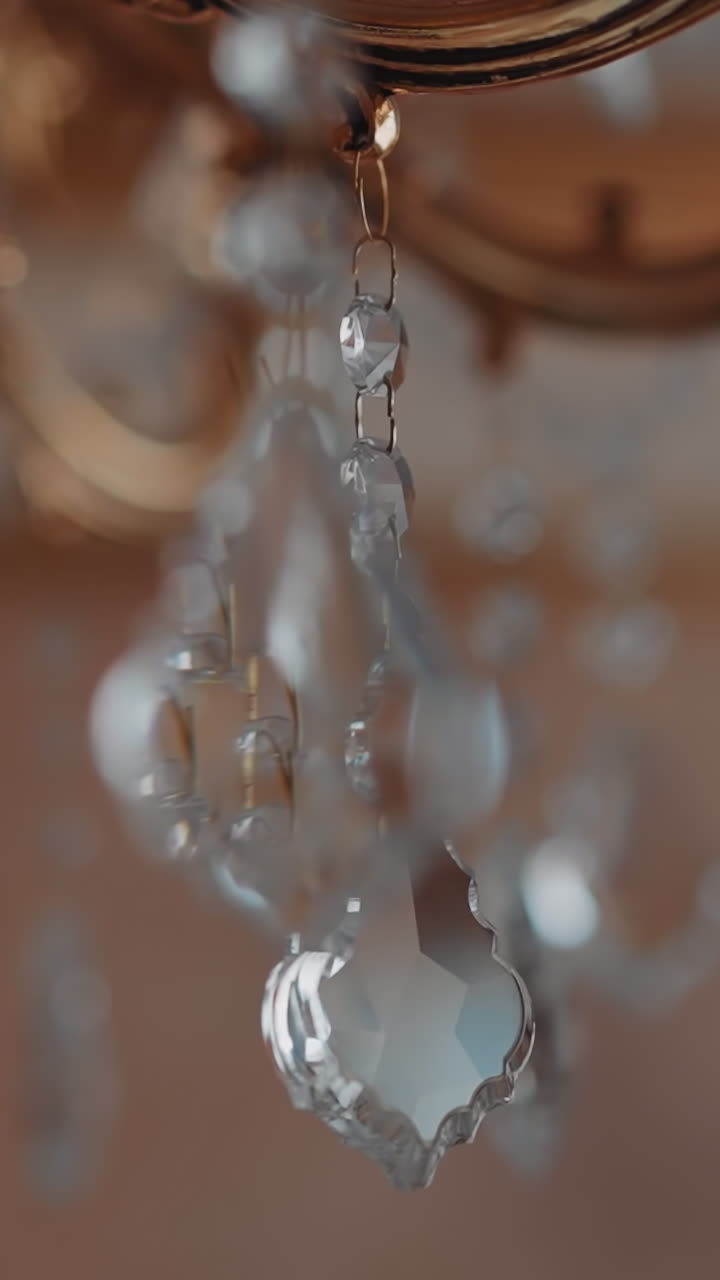 Sparkling crystal tears hang on vintage golden luster in palace macro view. Classic trend in home decor. Design ideas for domestic interior ornate