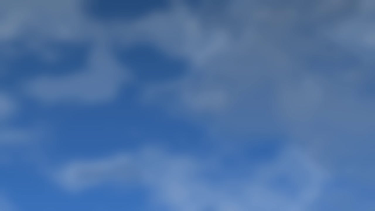 Soft white clouds drift slowly across a deep blue sky with organic movement and lighting