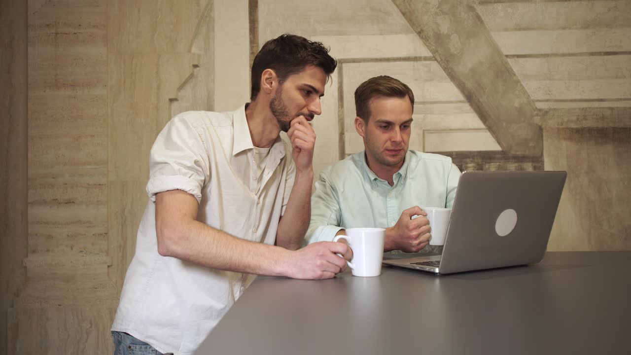 젊은 비즈니스 팀이 컴퓨터를 보고 이야기하고 있습니다.