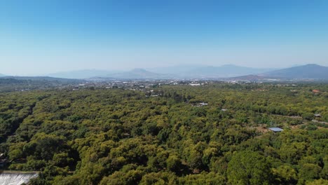 Aerial-pull-back-of-mountain-viewpoint-overlooking-flourishing-green-hass-avocado-ranch-in-Mexico-Michoacán