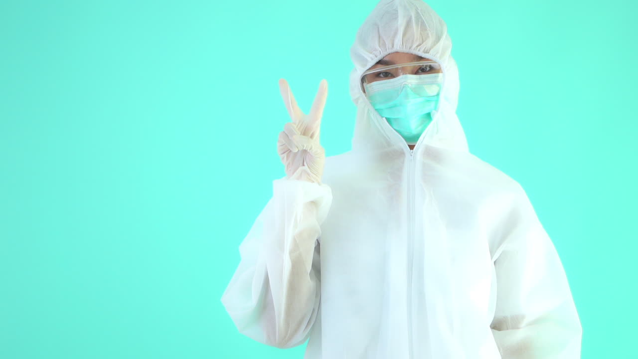 A woman in full protective gear flashes the victory sign