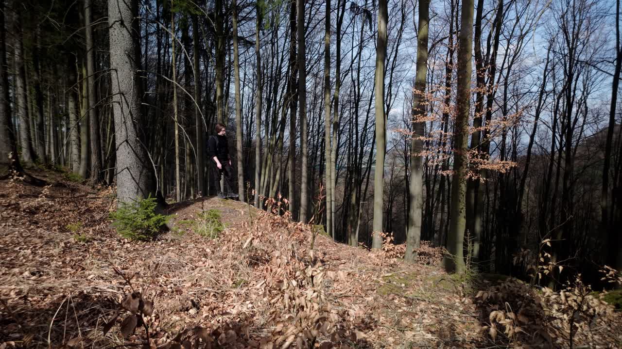 Man travels on a trip through the spring forest. The warm sun brings joy and energy.