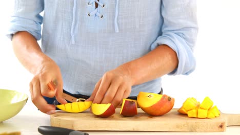 Woman-cutting-mango-on-chopping-board