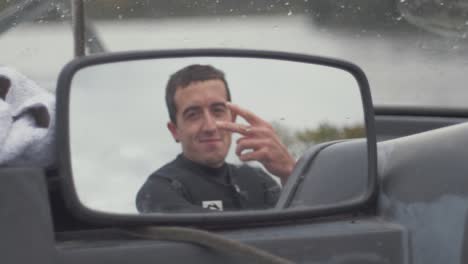 el joven mira en el espejo de la lancha rápida y da el signo de la paz