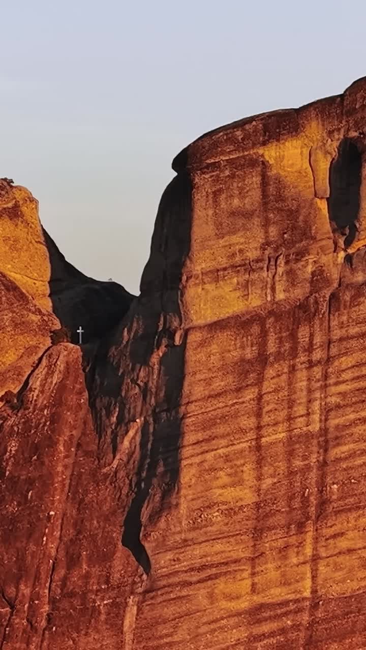 Monks climbing rocks in Greece at sunset in Meteora area