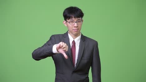 young asian businessman giving thumbs down