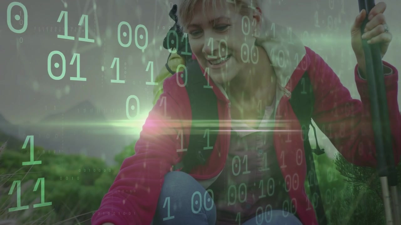 Hiker kneeling, touching purple flowers upon spotting, binary overlay over hand showing tech