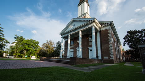 motion time lapse tilting up to a church as clouds move by in the sky above