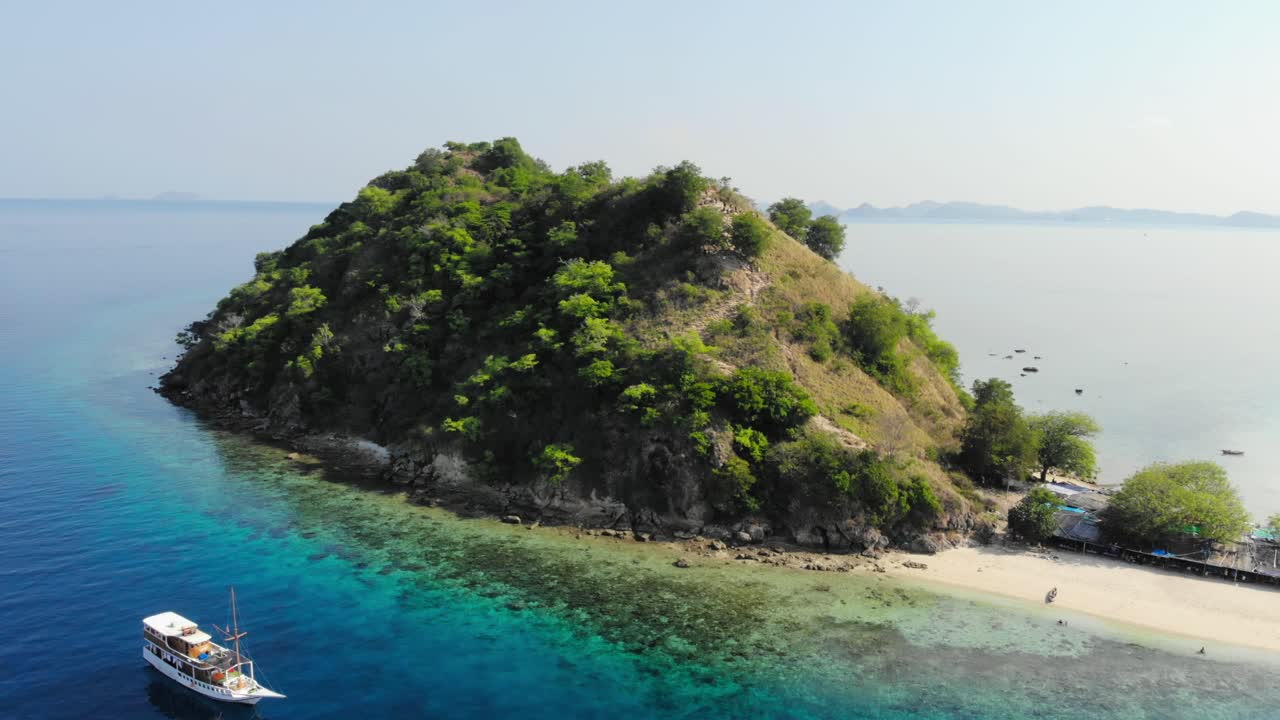 small Pulau Kelor island in Komodo Park, Indonesia, shot from a drone circling around it to showcase its beauty from all angles