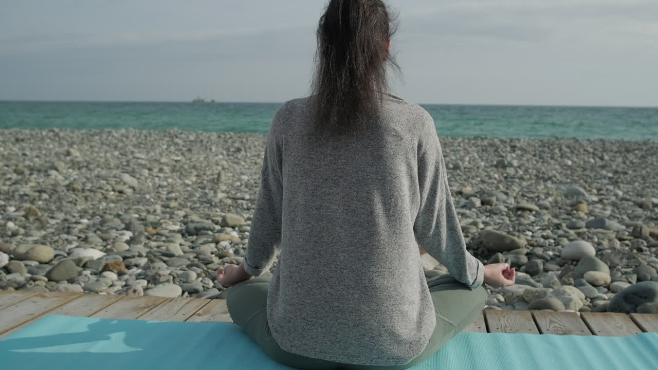 mujer meditando en una playa