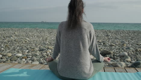 woman meditating on a beach