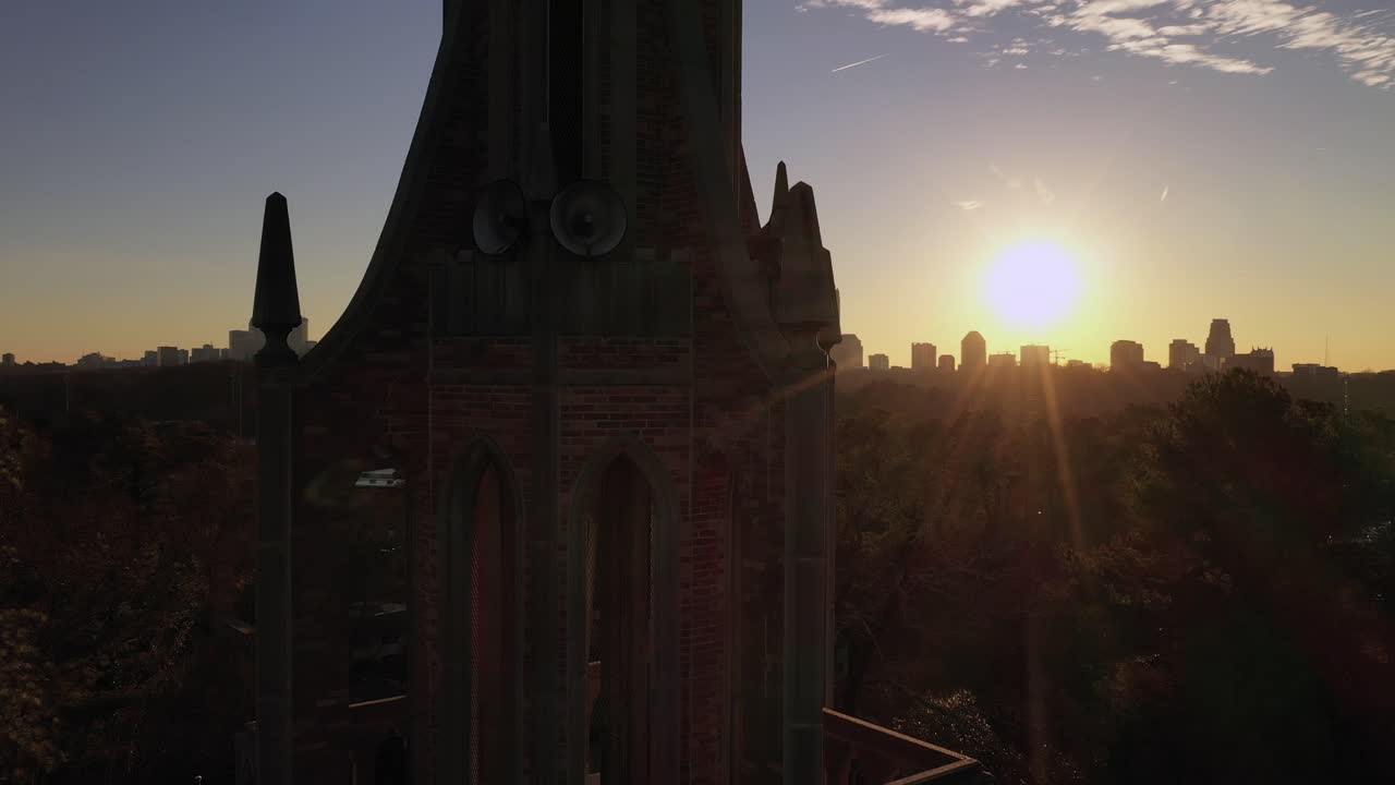 silueta del campanario de la iglesia, el sol y el centro de la ciudad en el fondo de atlanta.