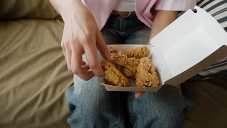 woman enjoying a crispy fried chicken wing