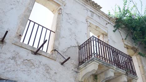 ruined building with balcony and rusty railing