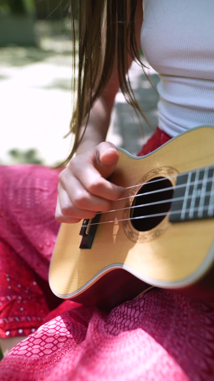mujer tocando el ukulele al aire libre