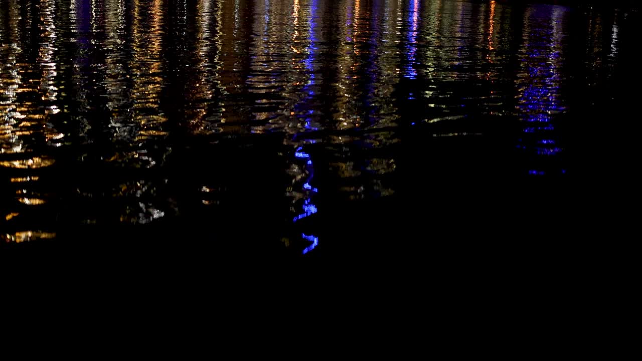 luces coloridas que se reflejan en el agua por la noche