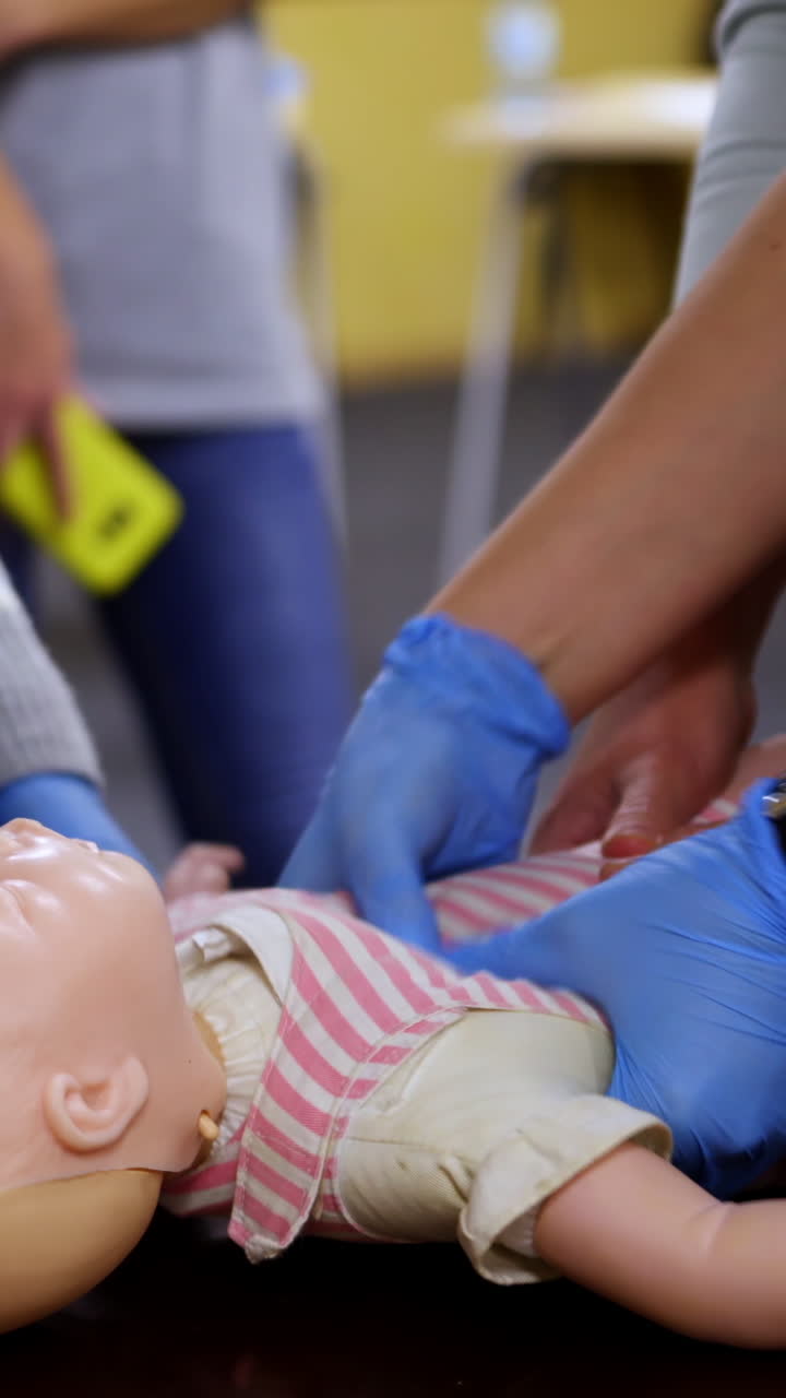 Newborn resuscitation on an infant dummy doll. First help medical class. Healthcare and education. Vertical video