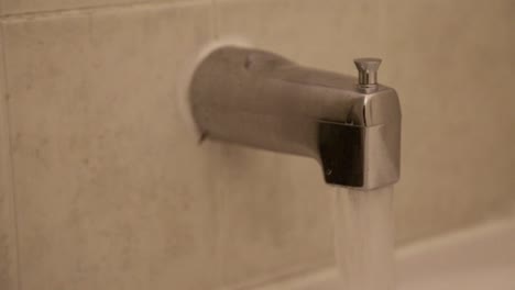 Close-up-of-a-tap-running-for-a-bath