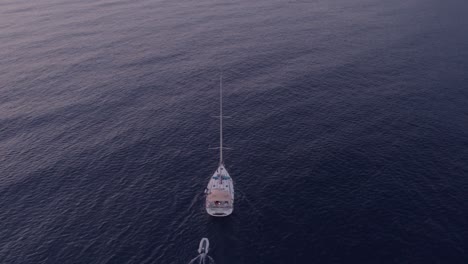 Sail-boat-cruising-during-sunset-at-Adriatic-ocean-at-Montenegro,-aerial