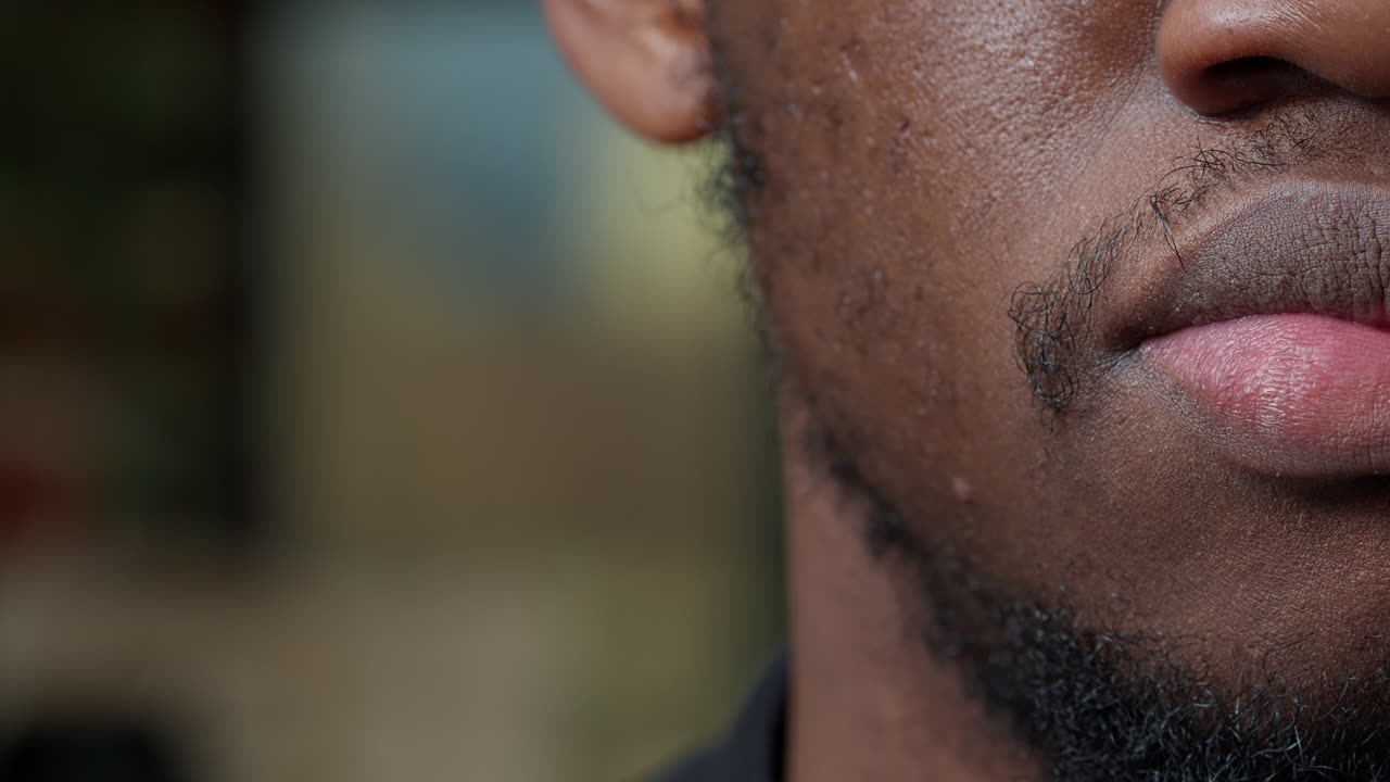 Macro shot of young man moving his lips and smiling
