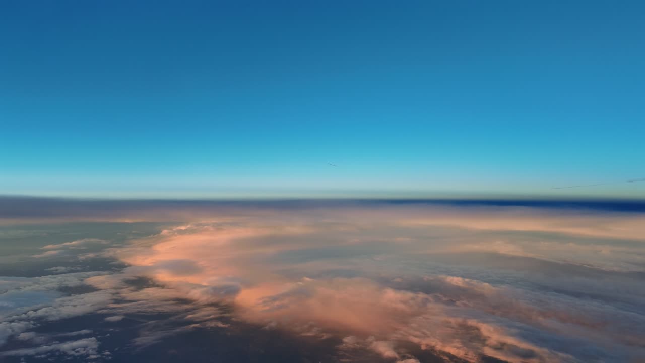 An immersive cockpit view from a jet airplane flying in the upper atmosphere at supersonic speed over a layer of ethereal golden clouds bathed by the warm light of the rising sun