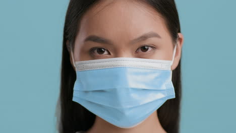close-up portrait of an asian woman wearing a medical face mask