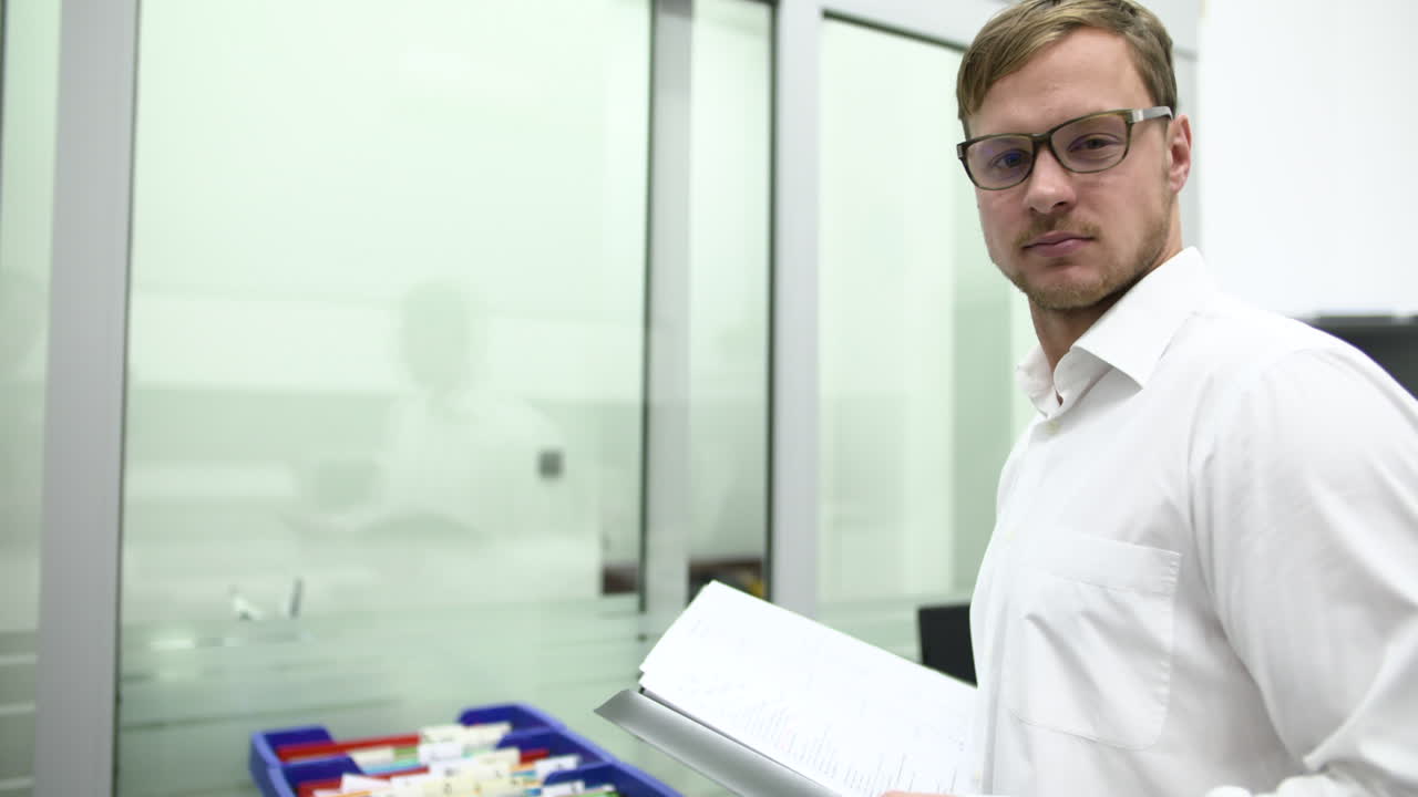 Uomo professionista con gli occhiali che tiene documenti in un ufficio