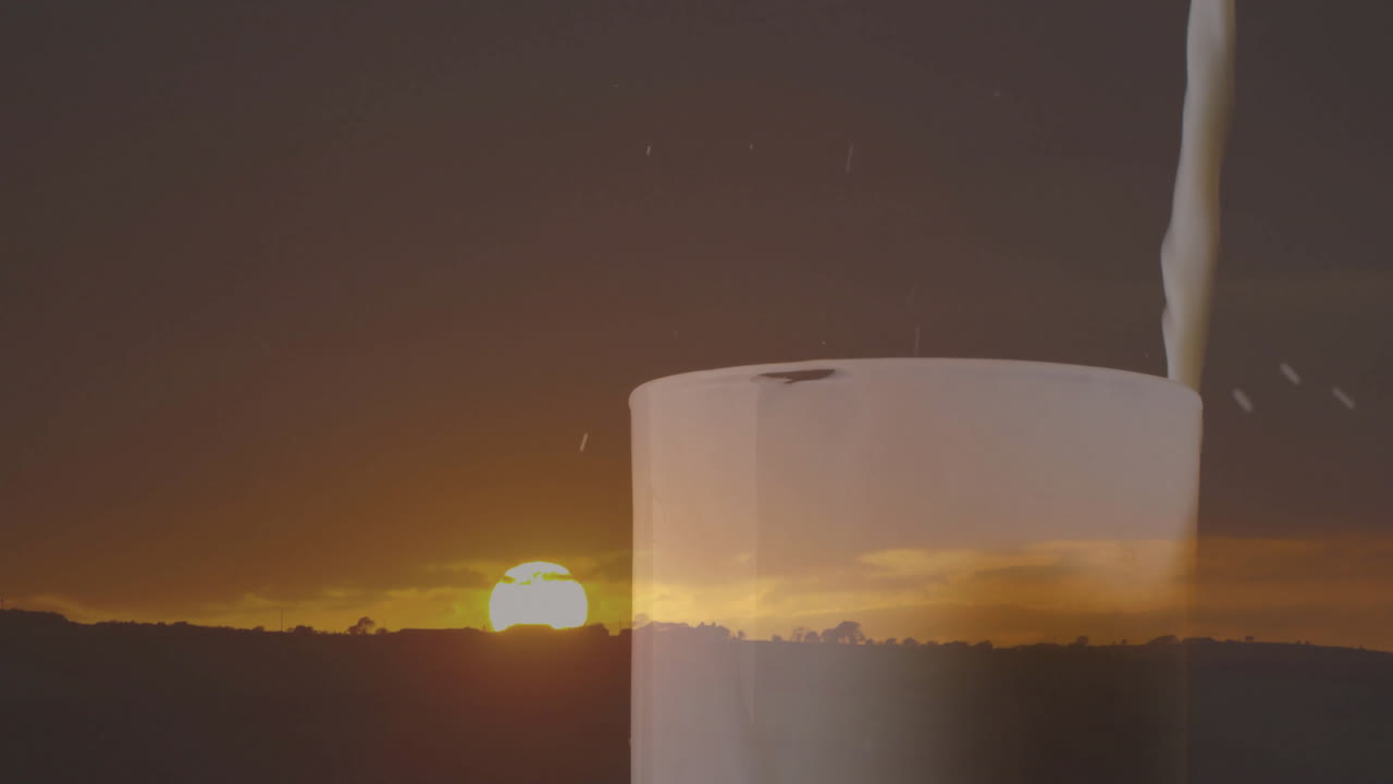 Pouring milk into glass, creating serene scene with sunset landscape animation