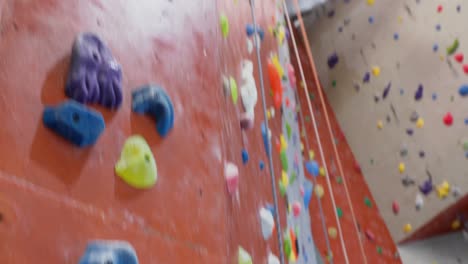 mujer tensa golpeando en la pared durante el bouldering 4k