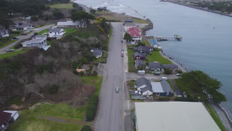 Plataforma-Rodante-Aérea-Sobre-Casas-Costeras-Junto-Al-Océano-Y-El-Río-Coquille,-Bandon,-Oregon