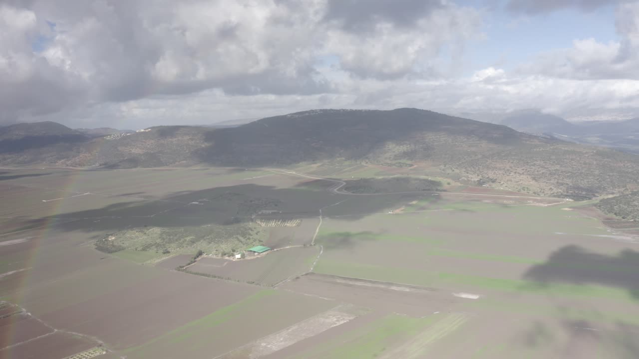 Aerial View of a Valley with Rainbow and Agricultural Fields