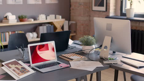 Empty-Animation-Studio-With-Modern-Furniture,-Computers-And-Documents-On-Desks