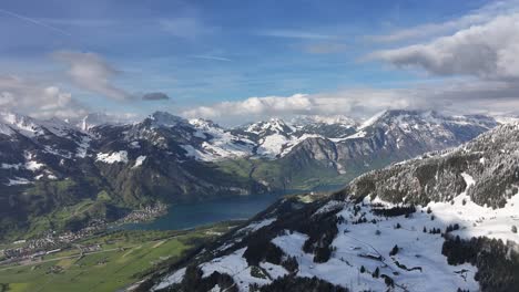 snowy majestic mountains, lake with cloudy sky, glarus, switzerland