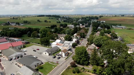 Hermosa-Antena-Ascendente-En-El-Pueblo-De-Intercourse,-Pennsylvania,-Condado-De-Lancaster-Con-Tierras-De-Cultivo-En-El-Horizonte