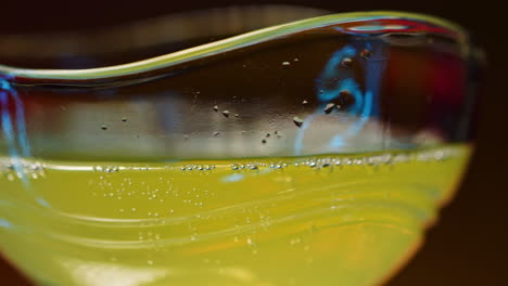 close-up of a sparkling yellow drink in a decorative glass