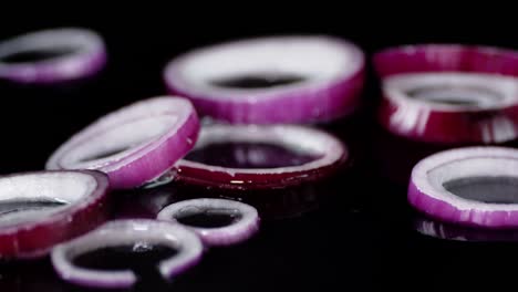 slices of red onion falling on the water with a splash.