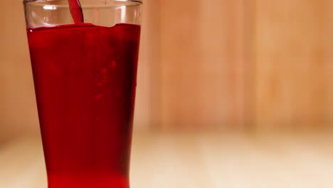 red beverage being poured into a glass