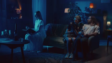 people engaged in different activities in a dimly lit living room at night