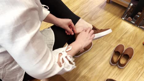 woman sitting and trying on shoes in a fashion store