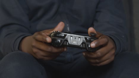 primer plano niño sosteniendo el controlador en casa sentado en el sofá jugando videojuegos