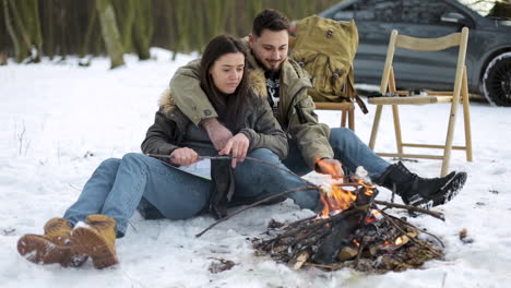 Caucasian-couple-camping-in-a-snowed-forest.