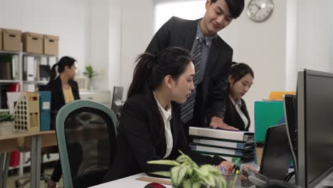 exhausted asian woman employee getting more tasks from her manager and colleague near off duty hours. workplace bullying concept